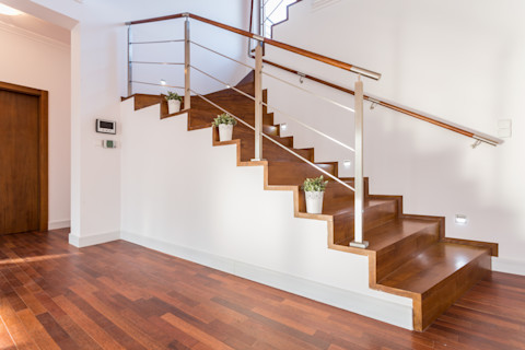Bloempotten op houten traptreden bij een luxe woning.
