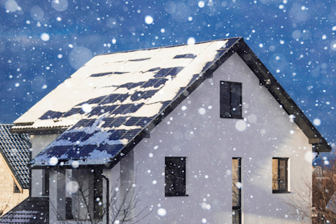 Zonnepanelen bedekt met sneeuw in de winter bij een zonne-energie installatie.