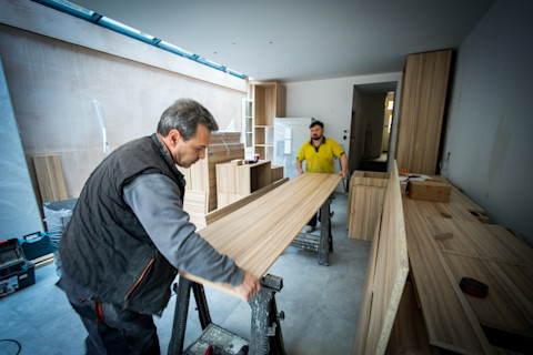 twee vakmannen werken met hout voor een aanbouw