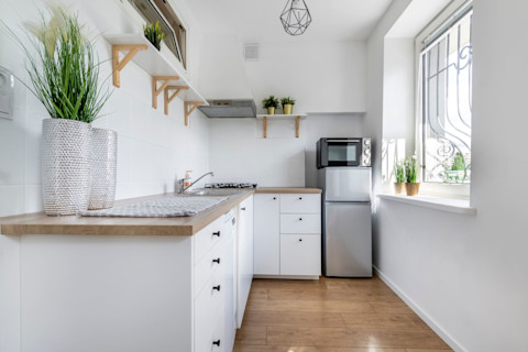 Moderne kleine keuken met witte afwerking en minimalistische uitstraling.