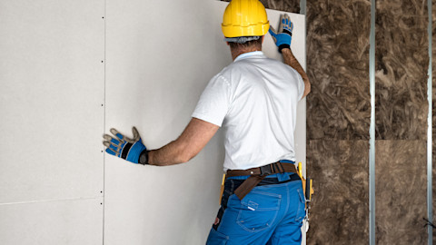 Een slanke en minimalistische wand van verticale latten, ideaal om leefruimtes van elkaar te scheiden zonder het gevoel van openheid te verliezen.