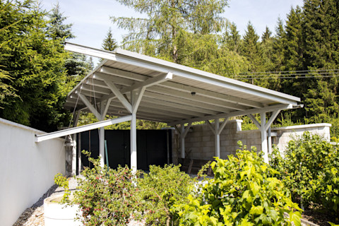 Eengezinswoning met een aangebouwde carport waar een auto onder is geparkeerd