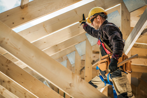 Dakdekker monteert het houten raamwerk voor het monteren van de nieuwe dakconstructie