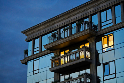 Een luxe groot balkon met glazen ruiten op een donker gebouw