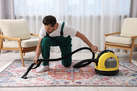 Vakman reinigt vloerkleed in woning  