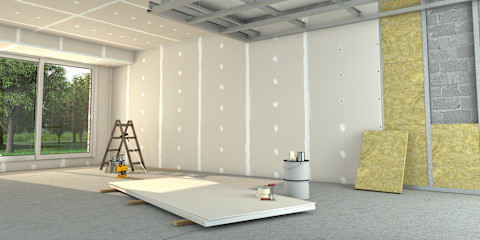 Een muur wordt met witte isolatieplaten geisoleerd in een grote ruime lege ruimte.