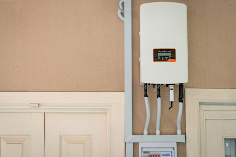 Een omvormer aan de muur die zonnestroom van zonnepanelen omzet naar bruikbare elektriciteit in huis.