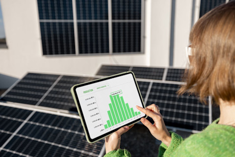 Vrouw controleert zonnepanelen verbruik op tablet