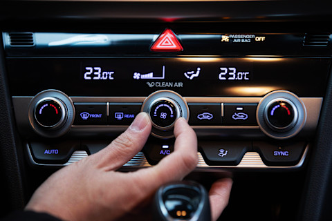 Man probeert de airco van de auto aan te zetten voor een aangename temperatuur onderweg