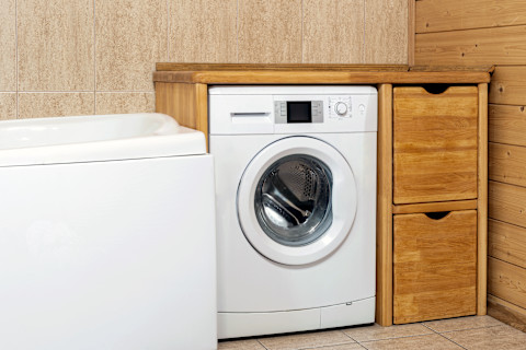 Houten ombouw voor een wasmachine in een badkamer