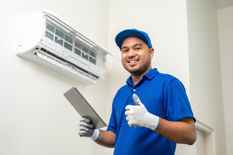 Airco installateur in uniform gebruikt een tablet om een checklist te controleren van de airco installatie