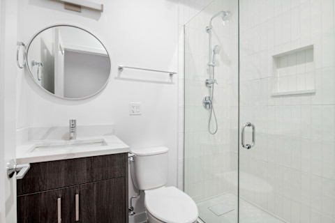 Moderne inloopdouche in een kleine badkamer die is uitgerust met een toilet en wastafel
