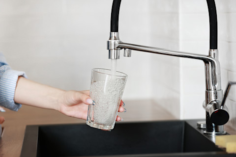 Een bruisend water tap met een glas eronder die wordt gevuld.