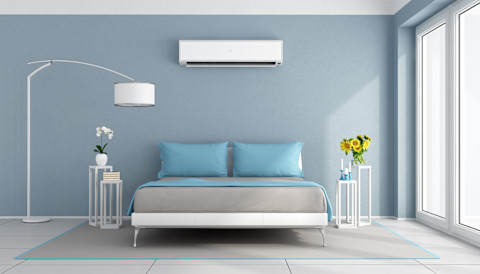 Moderne blauwe slaapkamer met wandgemonteerde airco, sfeervol verlicht en strak ingericht.