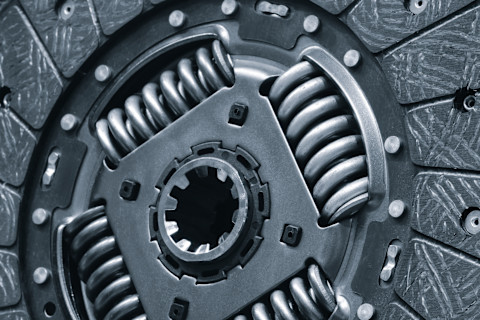 Koppelingsplaat en drukgroep van een auto liggen klaar voor vervanging tijdens een reparatie.
