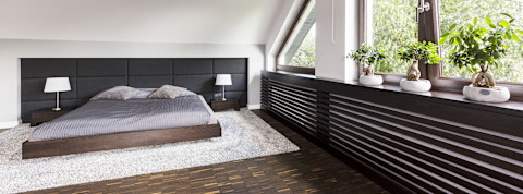 Zwarte ombouw voor een verwarming in een moderne slaapkamer