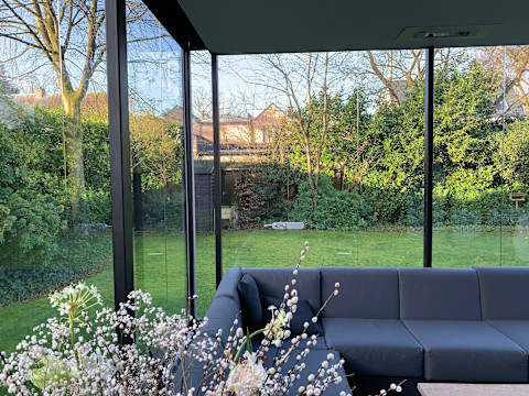 Moderne daktuin op een woning met luxe loungehoek, groene beplanting en stijlvolle buiteninrichting. De daktuin vormt een aangename leefruimte met veel groen en comfort.