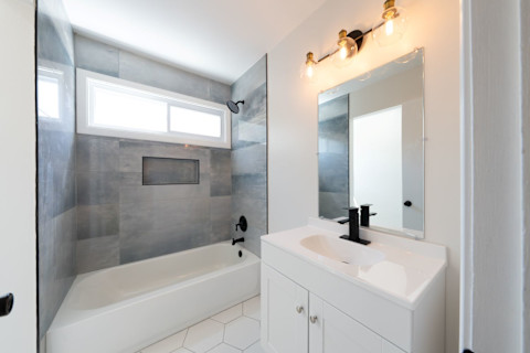 Moderne badkamer met nieuw wastafelmeubel, strakke tegels en een frisse, lichte uitstraling na renovatie.