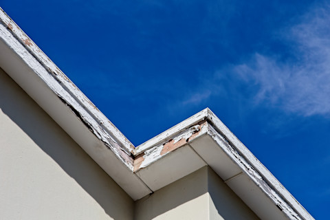 Dakwerker bezig met onderhoud aan windveren tijdens een dakreparatie.