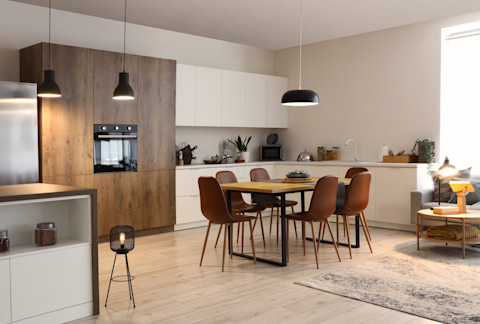 Open keuken en eethoek in één, met helder licht op werkbladen voor een uitnodigende look.