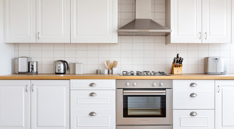 Witte keuken met roestvrijstalen apparaten en strakke kasten, modern en functioneel ingericht.