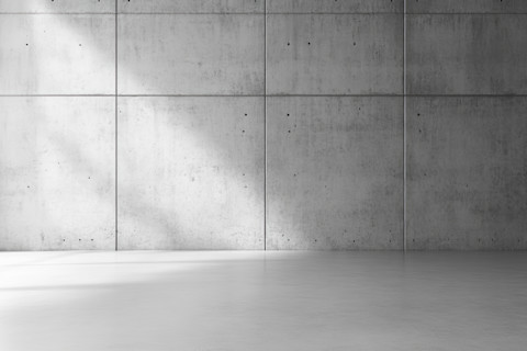 Minimalistisch modern interieur met een betonnen muur en vloer, strak en industrieel design.
