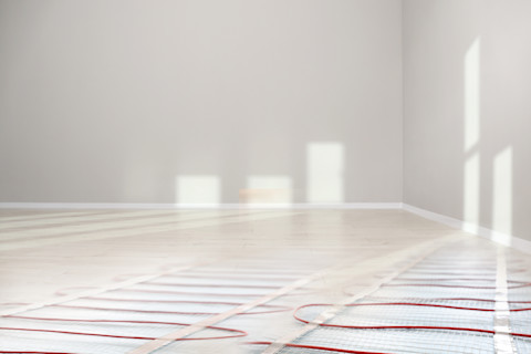 Laminaatvloer boven vloerverwarming, zichtbaar hoe warmte gelijkmatig door de vloer wordt verspreid.