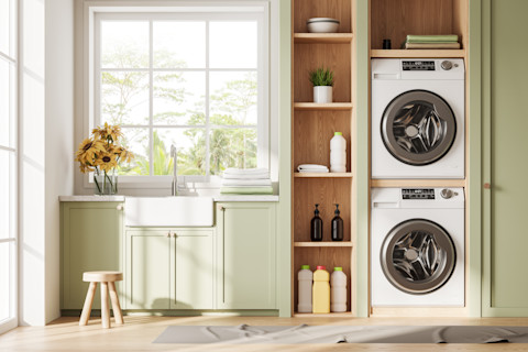 Stapelbare wasmachine in moderne bijkeuken met neutrale tinten en een vloerkleed als extra comfort.