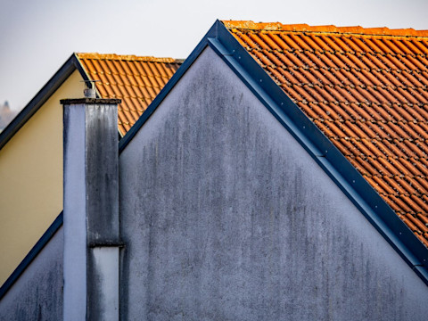 Vochtige buitenmuur met zichtbare vervuiling en schade door langdurige blootstelling aan regen.
