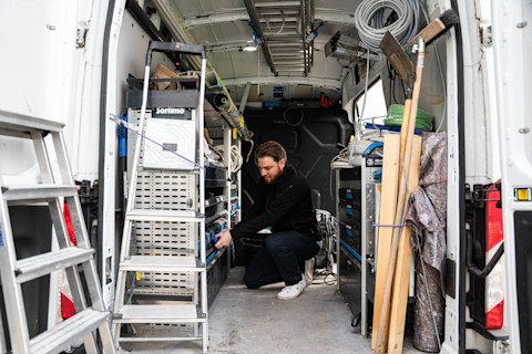 vakman sorteert gereedschap in een verhuisbus