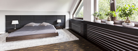 Zwarte ombouw voor een verwarming in een moderne slaapkamer