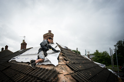 dakdekker werkt aan een dak om ruimte te maken voor een dakterras