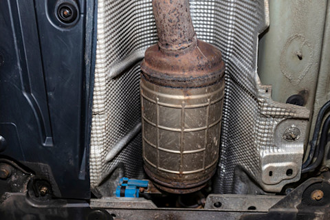 Roetfilter (DPF) van een auto-uitlaatsysteem in detail zichtbaar op een werkbank, klaar voor vervanging of inspectie.