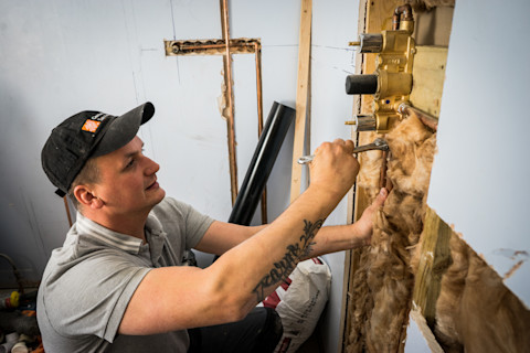 vakman werkt aan het aanleggen van een gasleiding in de muur van een woning