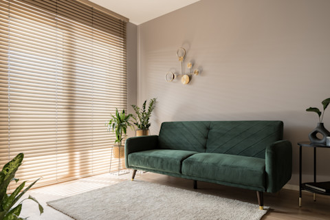 Elegante woonkamer met grote ramen, witte gordijnen en natuurlijke lichtinval.
