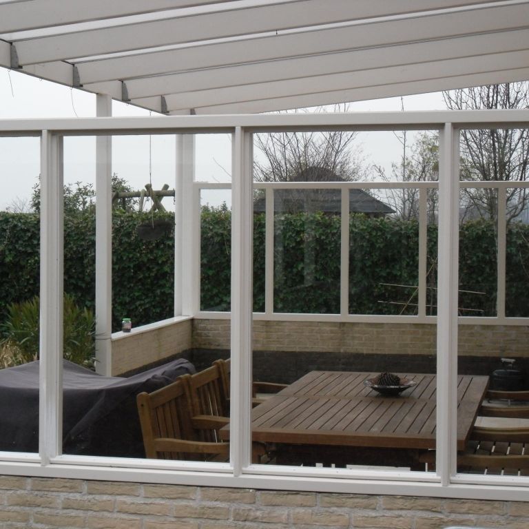 Kozijnen met glas plaatsen onder veranda