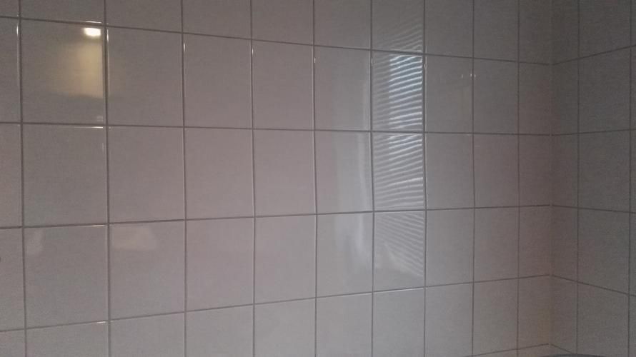 losse tegels in badkamer opnieuw vastzetten en voegen werkspot