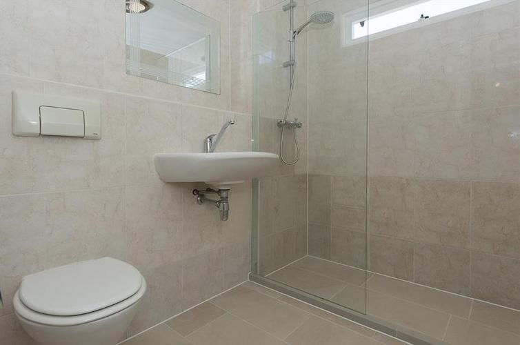 Inloop douche vloer opnieuw tegelen met afschot en douchegoot. Werkspot