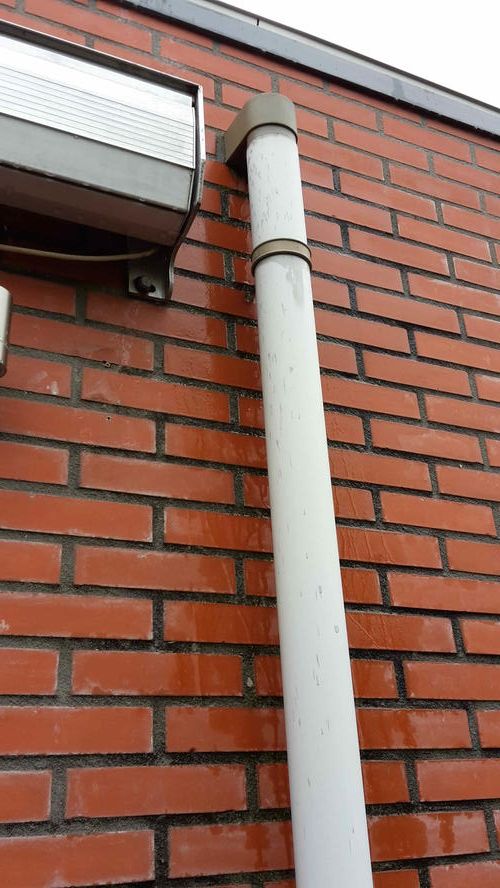 Lek op plat dak bij regenpijp, water loopt langs muur buiten en binnen Werkspot