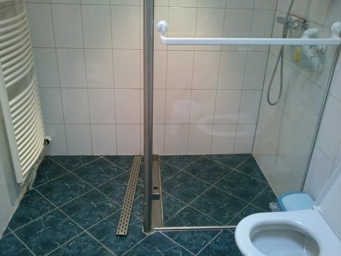 Afkitten douchegoot in vloer en naden tussen vloer en muur bij inlo